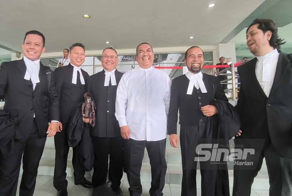 Sanusi (tiga dari kanan) tersenyum disamping barisan peguamnya, selepas Mahkamah Tinggi Shah Alam pada Isnin melepaskan dan membebaskannya daripada satu kes menghasut berkaitan Agong, dua tahun lalu.