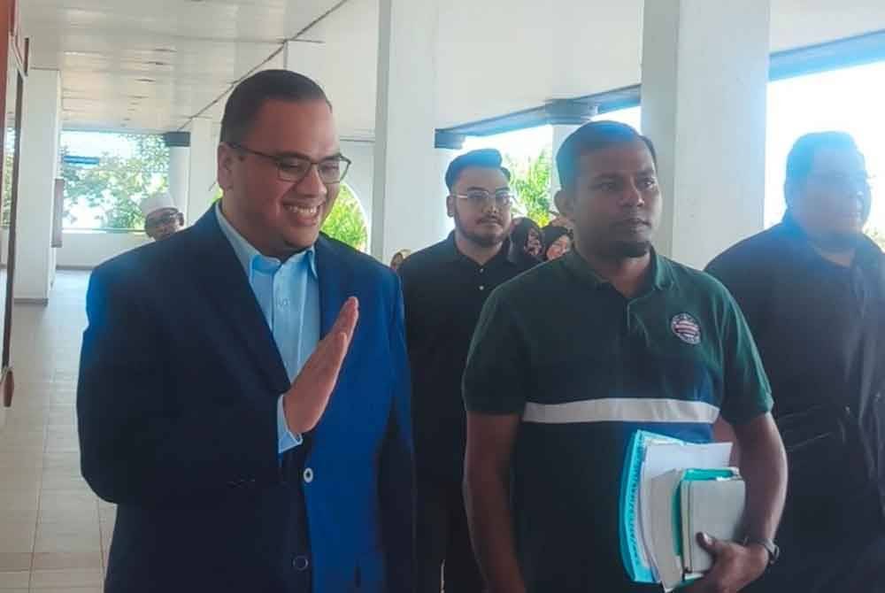 Ahmad Husam (kiri) selepas prosiding di Mahkamah Tinggi Alor Setar pada Isnin.