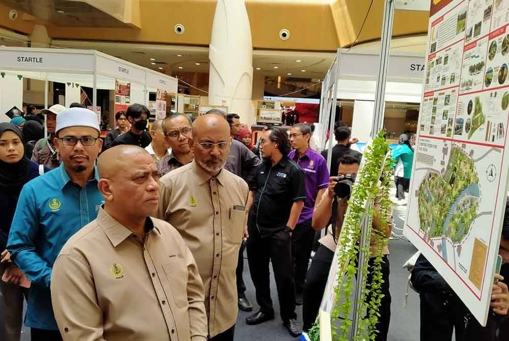 Saarani (kiri) melihat hasil inovasi peserta sempen Majlis Perasmian Penutup Program STARTLE yang diadakan di Pasar raya Besar Mydin Meru Raya di Ipoh pada Isnin.