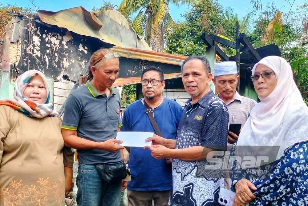Razak (empat dari kiri) menyerahkan sumbangan gabungan masjid kepada Amir(tiga dari kiri). Foto Sinar Harian