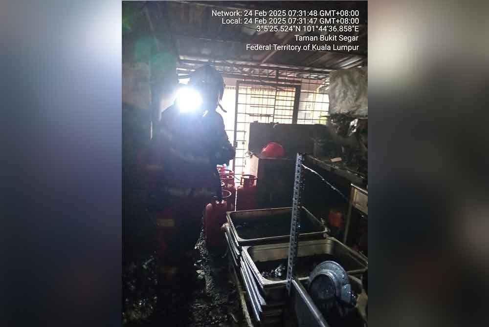 Anggota Bomba dan Penyelamat sedang memeriksa keadaan sebuah gerai makan di Taman Bukit Segar yang terbakar pada Isnin.