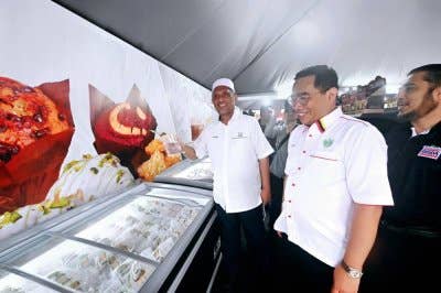 Syed Ibrahim ditemani Zainal melawat gerai usahawan selepas majlis perasmian Karnival RISDA Madani (KARRISMA) Zon Timur 2025 di pekarangan Stadium Darul Makmur, di sini, pada Sabtu.