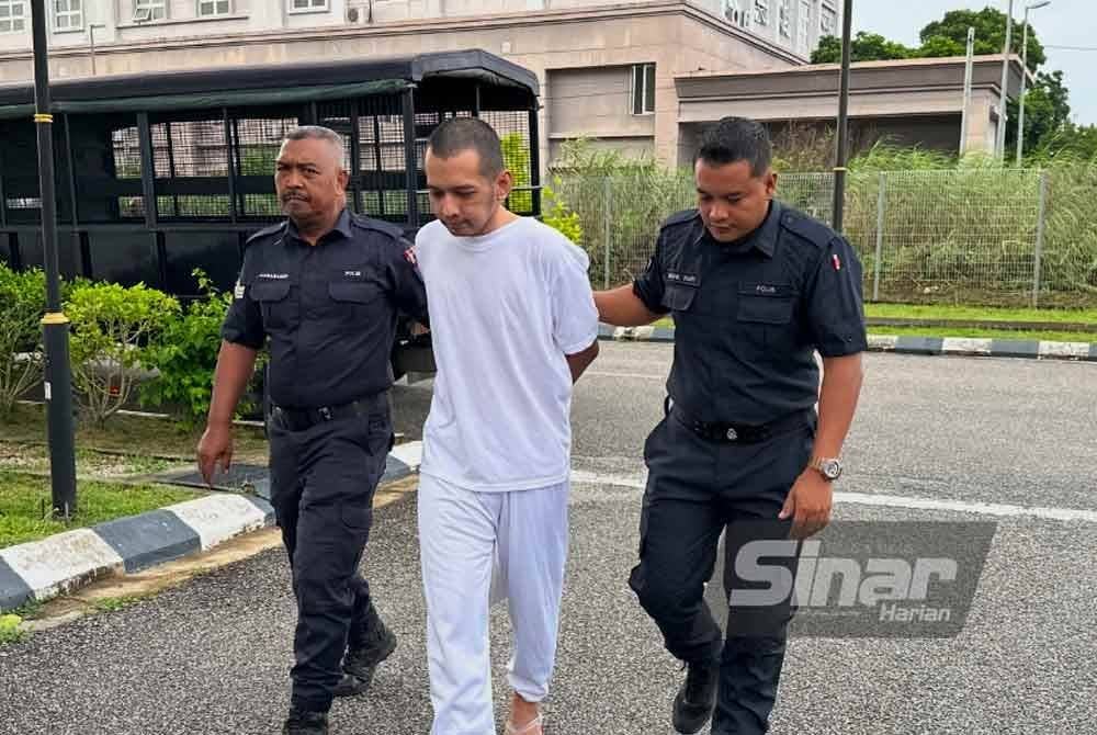 Hafizul (tengah) dikawal polis menuju ke lokap Mahkamah Kota Bharu. Foto Sinar Harian/ADILA SHARINNI WAHID