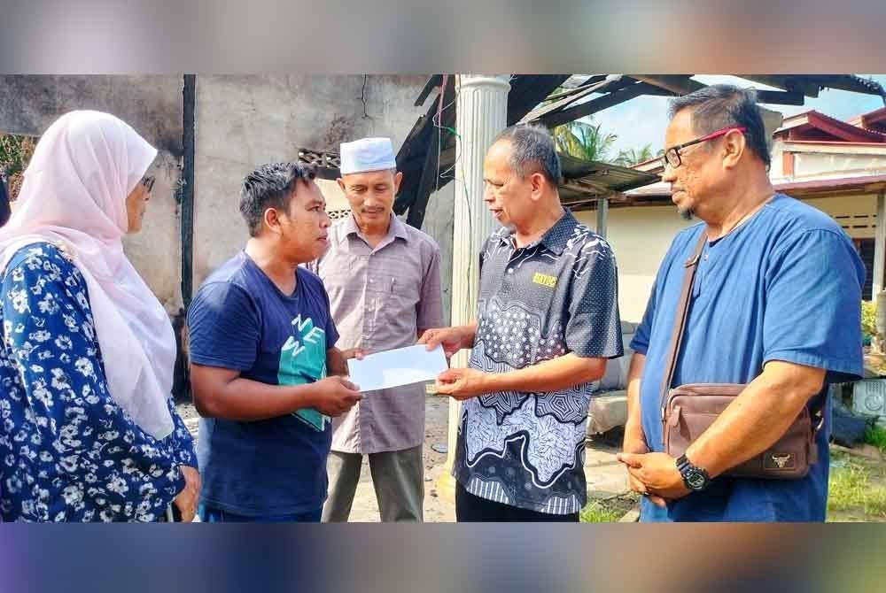 Zainudin (empat dari kanan) ketika menerima sumbangan yang disampaikan Razak (dua dari kanan)