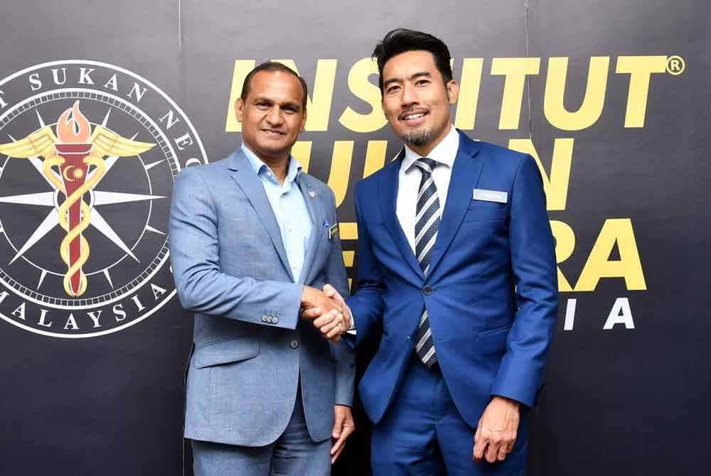 Vellapandian (kiri) bersalam Ahmad Faedzal ketika majlis serah tugas di ISN pada Selasa. Foto ISN