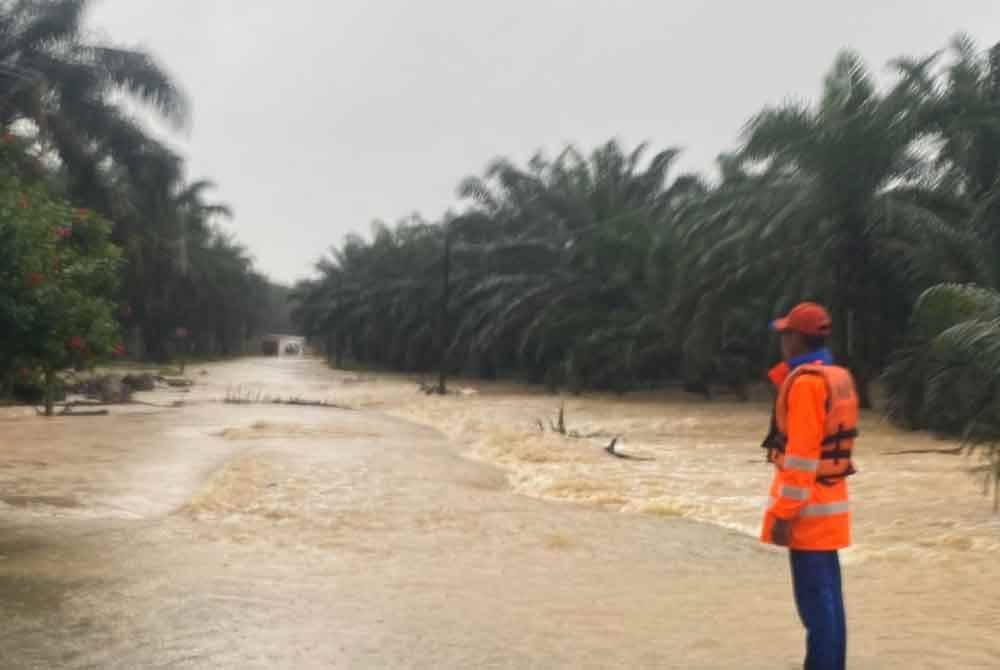 Anggota APM memeriksa laluan yang dinaiki air di jalan Pasir Gajah, Kuala Krai pada Selasa. FOTO: APM