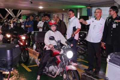 Makhzan (dua, kanan) diiringi Timbalan Ketua Imigresen (Kawalan), R Vimala (kanan) meninjau laluan motosikal pada Media Tour Status Pelaksanaan Inisiatif Menangani Kesesakan di CIQ Bangunan Sultan Iskandar Johor pada Selasa. Foto Bernama