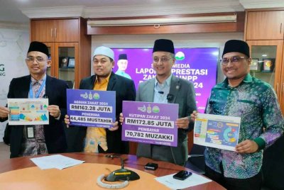 Mohamad (dua dari kanan) bersama Rosidi (kanan), Mohd Suki (dua dari kiri) dan Mohamad Khairi (kiri) menunjukkan kad prestasi Zakat MAINPP pada 2024.