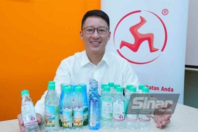 Chris bergambar bersama beberapa produk keluaran syarikatnya. Foto Sinar Harian/MOHD HALIM ABDUL WAHID