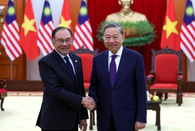 Anwar (kiri) mengadakan kunjungan hormat ke atas To Lam di Ibu Pejabat Parti Komunis Vietnam pada Selasa. Foto Bernama