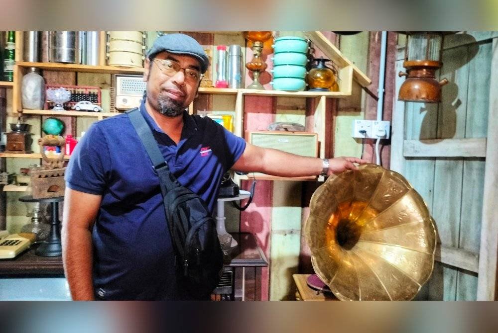 Azizan bersama monogram yang turut menjadi antara koleksi antik di kafe tersebut.