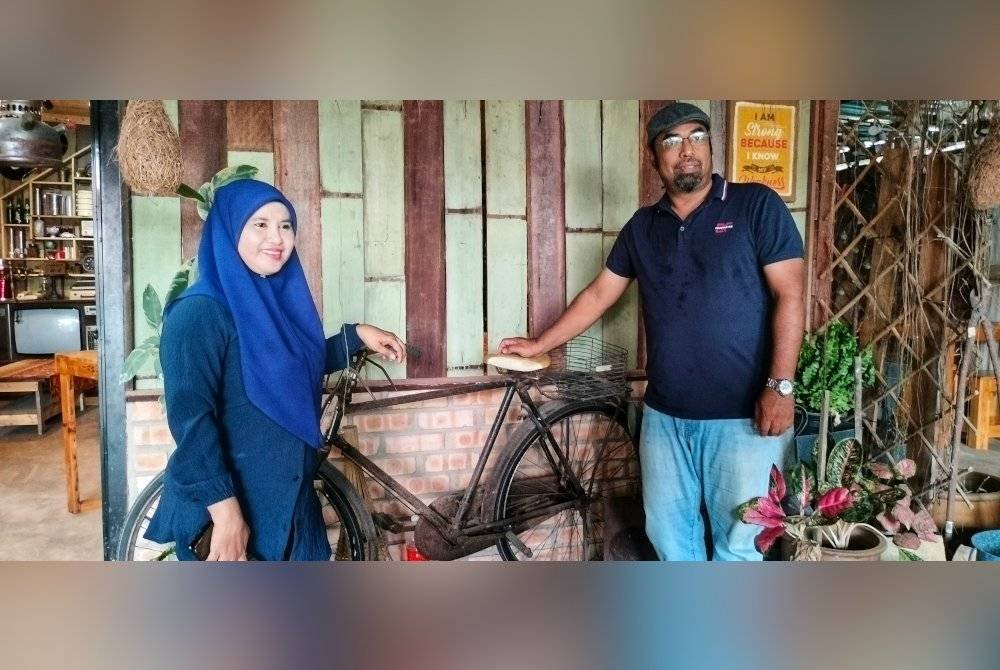 Azizan dan Nor Eda bersama basikal model Raleigh yang dipamerkan di kafe itu.