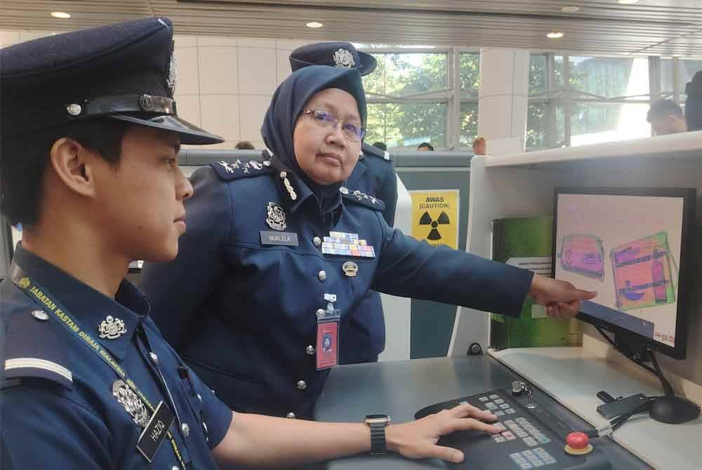 Norlela menunjukkan hasil imbasan imej dikesan mesin pengimbas AI di Terminal 1 KLIA, Sepang pada Rabu.