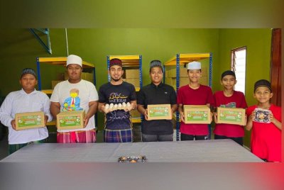 Pelajar Maahad Tahfiz Al-Quran Al-Marjunidy menunjukkan telur masin yang dihasilkan.