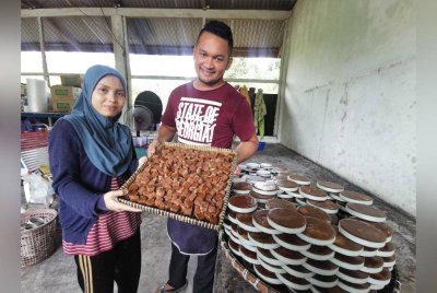 Nor Afila dan Nazif Ikhwan menunjukkan manisan tradisional, nisan kerek yang dihasilkan di kediaman mereka di Kampung Jenang, Marang.