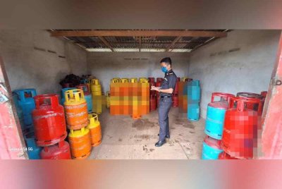 Pegawai KPDN Perak melakukan pemeriksaan di sebuah premis yang dijadikan stor haram menyimpan gas LPG di Selama pada Selasa. Foto: ihsan KPDN Perak