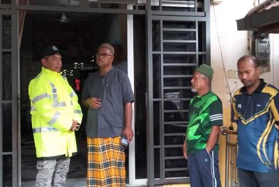 Mohd Haki (kiri) bertanya khabar ahli keluarga mangsa ketika tinjauan pencarian pada Rabu