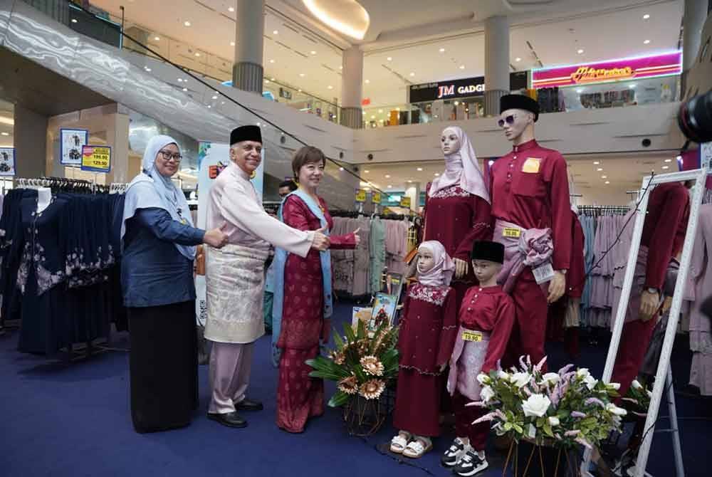 Ameer (tengah) mengiringi Nicole meninjau set baju raya ditawarkan di Mydin.