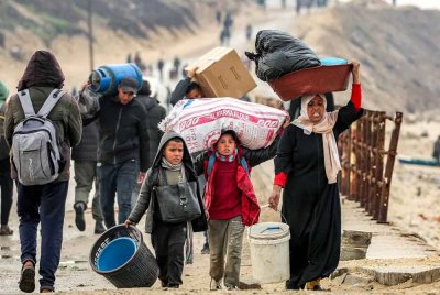 Penduduk Gaza membawa barangan peribadi dilihat berjalan menuju ke rumah masing-masing di Genting Gaza selepas gencatan senjata dipersetujui antara Hamas-Israel. - AFP