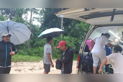 Pasukan perubatan melakukan pemindahan pesakit ke ambulans selepas berjaya merentasi laluan terjejas akibat cerun runtuh di Jalan Ranau-Tambunan, Kampung Pahu, Tambunan.