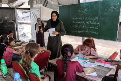 Kanak-kanak menghadiri kelas tatabahasa Arab di dalam khemah yang digunakan sebagai pusat pendidikan untuk murid sekolah rendah di Jabalia, utara Semenanjung Gaza. - Foto: AFP
