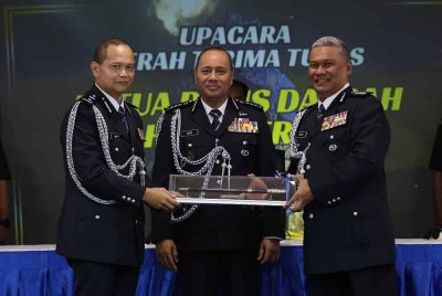 Noor Hisam (tengah) menyaksikan serah terima tugas antara Senior Asisten Komisioner Ahmad Adnan dengan Asisten Komisioner Dr Bakri (kanan) di Mes Pegawai Kanan Polis Perak di Ipoh.