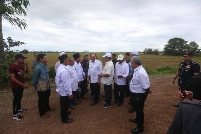 Anwar bersama beberapa petani selepas meluncurkan Projek Pembangunan Infrastruktur Bagi Menyokong Program Penanaman Padi Lima Musim Dalam Tempoh Dua Tahun di kawasan Muda di Kampung Pida 4, Ayer Hitam, Jerlun pada Khamis.