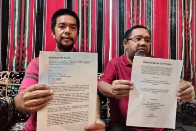 Asran (kiri) dan Hisham menunjukkan memorandum bantahan larangan pemindahan premis