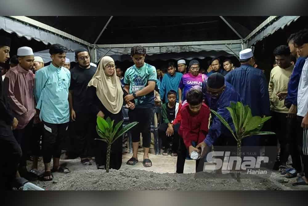 Ahli keluarga menyiram air di pusara Muhammad Haziq Uzayr sebaik selesai pengebumian di Tanah Perkuburan Islam Masjid Tunku Sallehuddin Bandar Puteri Jaya Sungai Petani.
