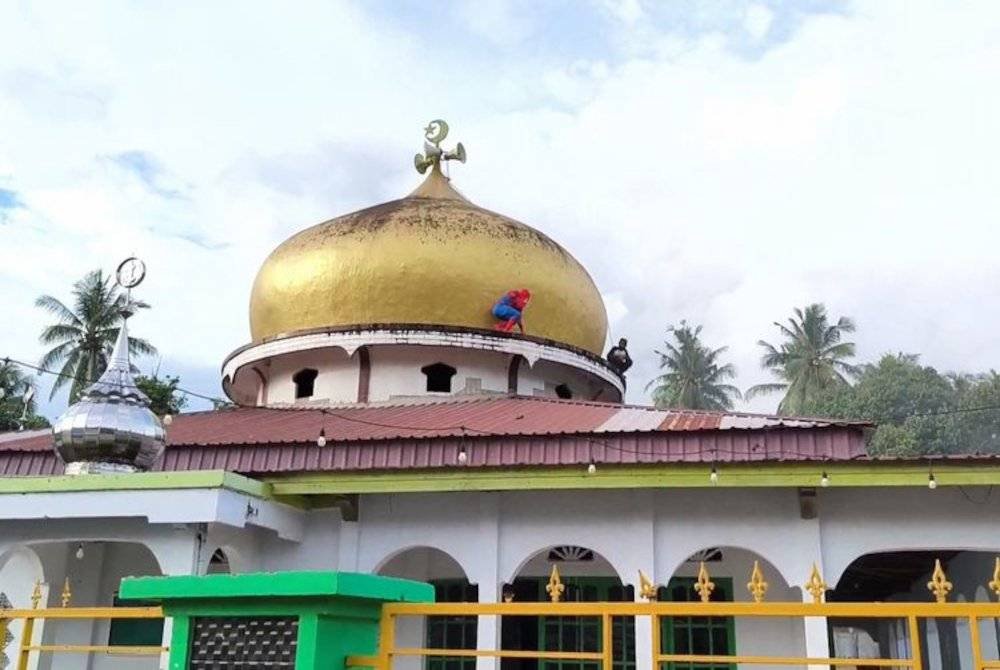 Aksi dia memanjat kubah masjid setinggi lebih 30 meter tanpa sebarang alat keselamatan, menjadi tontonan penduduk setempat.