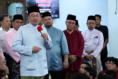 Anwar menyampaikan ucapan kepada para pelajar selepas menunaikan solat Jumaat di Masjid Sekolah Sultan Alam Shah, Presint 1, pada Jumaat. Foto Bernama