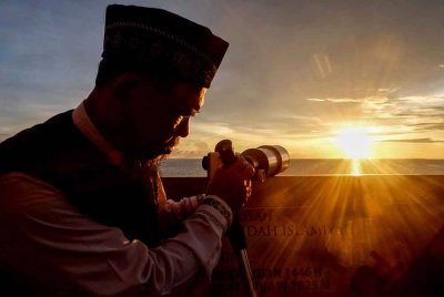 Seorang pegawai balai cerap menggunakan teleskop untuk menentukan permulaan bulan puasa Ramadan berdasarkan penampakan anak bulan di Makassar, Sulawesi Selatan. Foto AFP