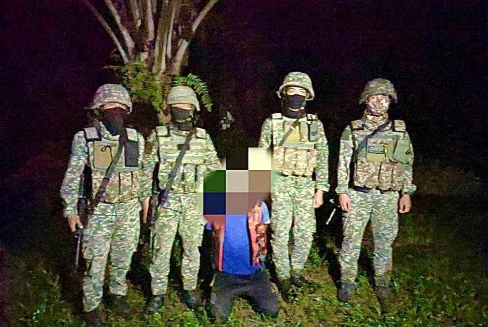 Salah seorang suspek (tengah) yang dapat ditahan oleh pihak berkuasa.