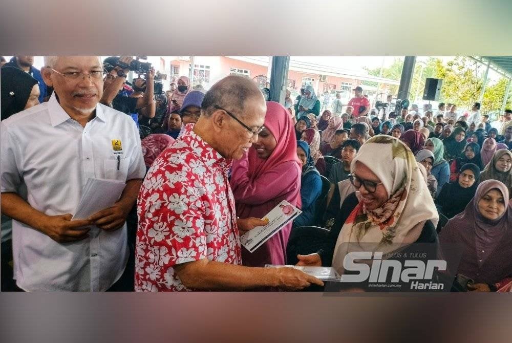 Wan Rosdy (dua dari kiri) menyerahkan sumbangan kepada penerima.
Foto Sinar Harian