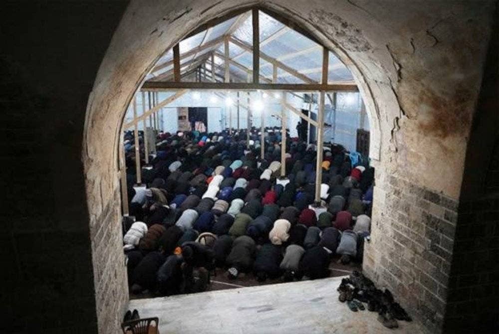 Rakyat Palestin menunaikan solat Tarawih pertama di Semenanjung Gaza di celah runtuhan masjid pada Jumaat malam. Foto Agensi