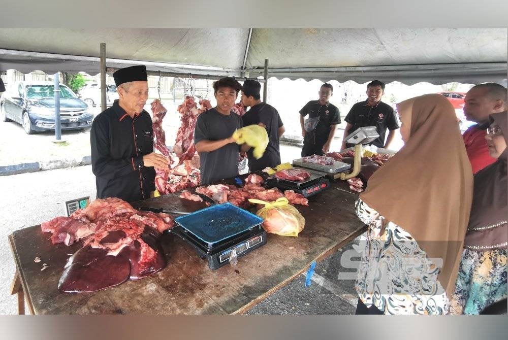 Shaikh Harun (kiri) meninjau Jualan Daging Rakyat di pekarangan Masjid Wakaf Tembesu, Gong Badak, di Kuala Nerus pada Sabtu.