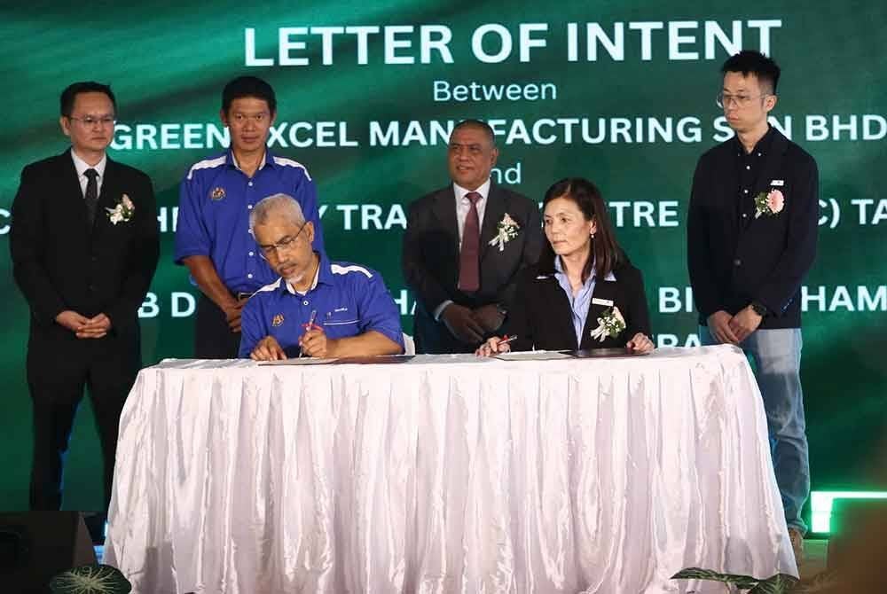 Saarani (berdiri, dua dari kanan) menyaksikan majlis menandatangani memorandum persefahaman (MoU) antara Green Excel Manufacturing dan Pusat Latihan Teknologi Tinggi (Adtec) Taiping pada perasmian pembukaan kilang itu di Kamunting pada Sabtu.
