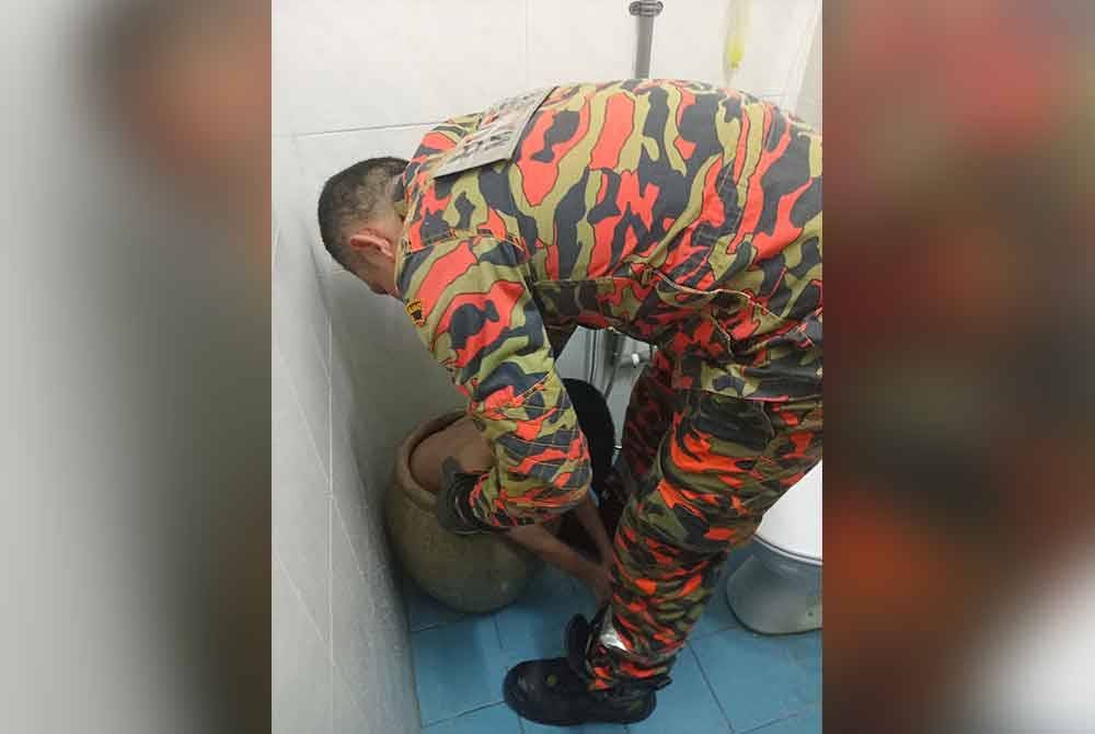 Anggota bomba menjalankan kerja-kerja mengeluarkan mangsa yang tersangkut dalam tempayan di Pangsapuri Saujana Damai, Jalan Raya Barat pada Sabtu.