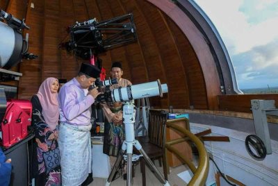 Fadzli (tengah) mendengar penerangan mengenai alatan digunakan di Balai Cerap KUSZA ketika Program Cerapan Hilal Ramadan 1446H di Merang, Setiu.