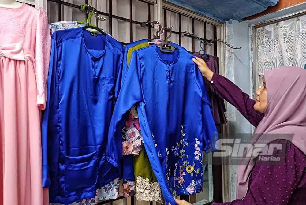 Hasnuriza menunjukkan tempahan baju raya yang sudah siap dijahit.