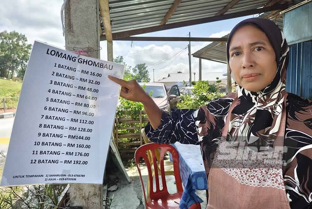 Julia menunjukkan harga lemang dijualnya.