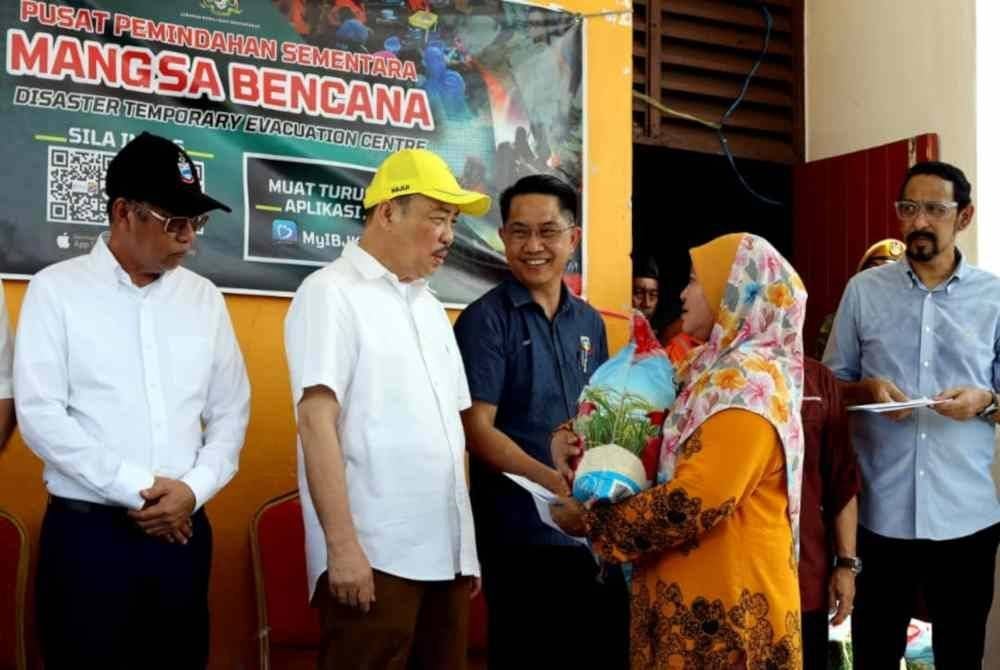 Hajiji menyampaikan sumbangan tunai dan bakul makanan ketika melawat mangsa kebakaran Kampung Cempaka di Dewan Serbaguna Likas, Kota Kinabalu.