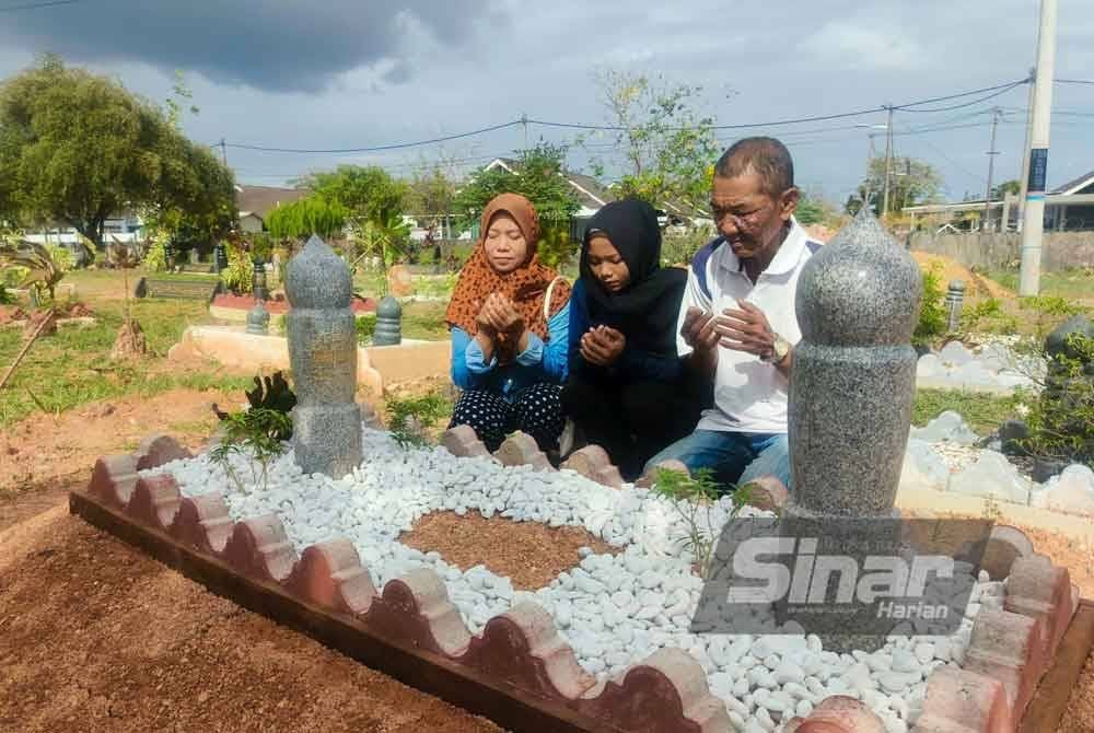 Dari kanan, Mohd Zaini, Naila Kasniza dan Siti Ramlah semasa menziarahi pusara Allahyarham Muhammad Muslim di Tanah Perkuburan Islam Masjid As-Salam, Tambak Bunga, Kuala Kedah pada Isnin.