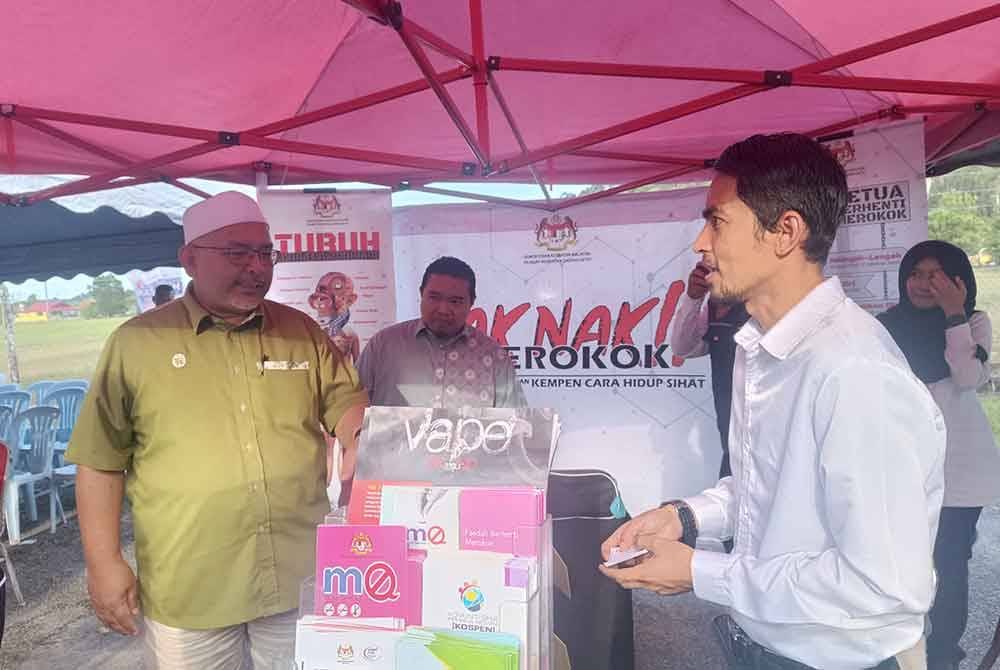 Wan Sukairi (kiri) melawat reruai mengenai kempen kesedaran Tak Nak Merokok di Bazar Ramadan Sungai Tarom, Bandar Permaisuri pada Isnin.