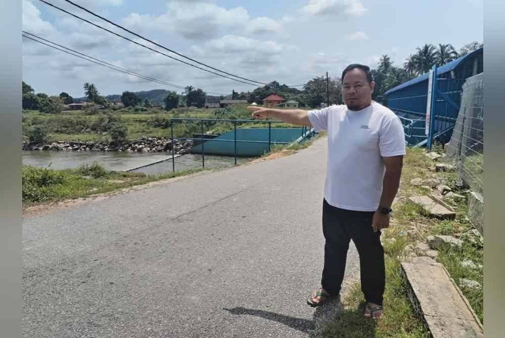 Mohd Azril Hafiz menunjukkan penemuan buaya di Sungai Kampung Buruk