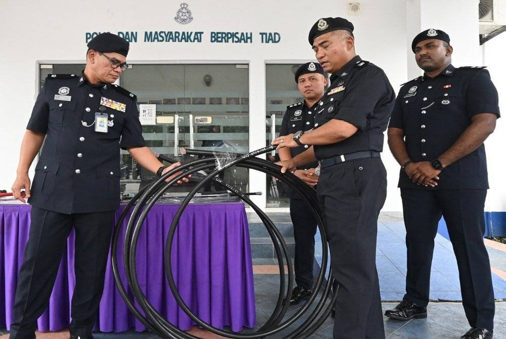 Ashari (dua dari kiri) menunjukkan gelung kebel yang dicuri kumpulan sindiket itu.