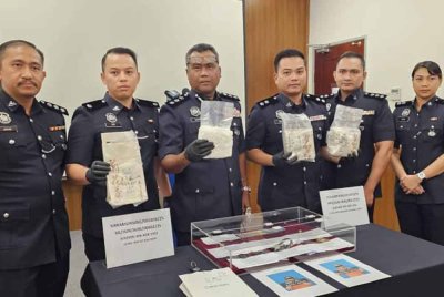 Kasim (tiga dari kiri) menunjukkan syabu yang berjaya dirampas dalam serbuan di Api-Api Centre, Kota Kinabalu.