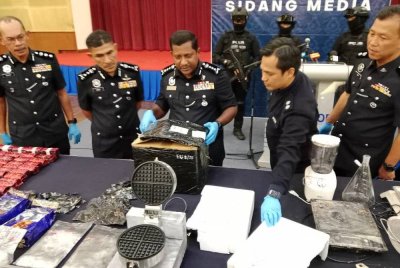 Hussein menunjukkan mesin pembuat wafle dalam sidang akhbar di Ibu Pejabat Polis Kontinjen (IPK) Selangor pada Selasa.
