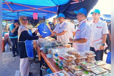 Razali mengedarkan kit pengendali makanan kepada pengusaha gerai sempena Majlis Pelancaran Walkabout Kempen Keselamatan Makanan di Bazar Ramadan di Tapak Bazar Ramadan.