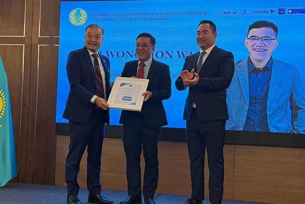 Hon Wai (tengah) menerima cenderahati daripada Ng (kiri) dan Bulat Sugurbayev ketika menghadiri Forum Perniagaan Kazakhstan-Malaysia.
